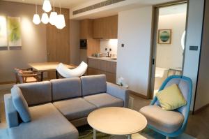 瓊海的住宿－瓊海官塘假日度假酒店，客厅配有沙发和桌椅