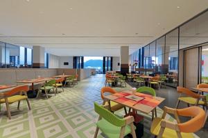 a restaurant with tables and chairs and windows at Holiday Inn Resort Qionghai Guantang, an IHG Hotel in Qionghai