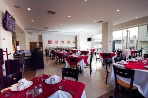 a restaurant with red and white tables and chairs at Balaju Hotel & Suites in Veracruz