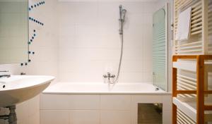 ein weißes Badezimmer mit Badewanne und Waschbecken in der Unterkunft Bright Suite Universitaet Wien in Wien + 17 Fotos