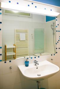 y baño con lavabo blanco y espejo. en Bright Suite Universitaet Wien en Viena