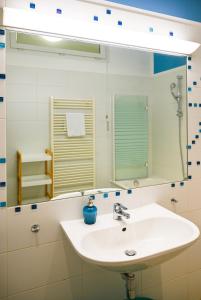 ein Badezimmer mit einem weißen Waschbecken und einem Spiegel in der Unterkunft Bright Suite Universitaet Wien in Wien
