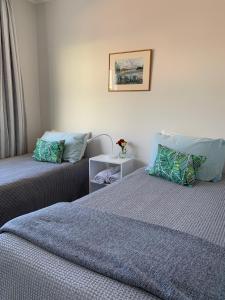 a bedroom with two beds and a table with flowers at The Villa in Picton