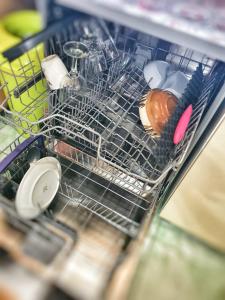 a dish rack in a dishwasher filled with dishes at CABANA ZIMBROAIA 8 camere -Muntii Bârgăului, Transilvania in Piatra Fantanele
