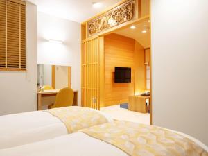 una camera d'albergo con un letto e una televisione di Tanakaya Kyoto Karasuma a Kyoto