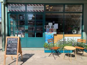a store with a table and chairs in front of it at Busket Hostel in Chiang Rai