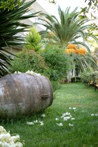 an old barrel sitting in the grass in a garden at Hotel Antonios in Olympia
