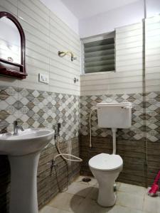 a bathroom with a toilet and a sink at SAHARA Inn in Bangalore