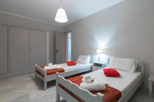 1 Schlafzimmer mit 2 Betten und roten Kissen in der Unterkunft The Lofos Studios in Alykes