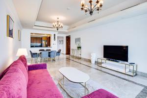 a living room with a purple couch and a table at South & North Residence Palm Jumeirah in Dubai