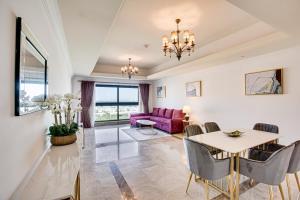 a living room with a table and a purple couch at South & North Residence Palm Jumeirah in Dubai