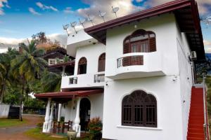 a white house with a red roof at Green Heritage Holiday Resort in Mahiyangana