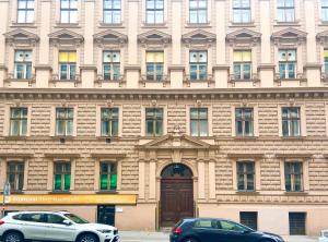 ein Gebäude mit zwei davor geparkten Autos in der Unterkunft Bright Suite Universitaet Wien in Wien