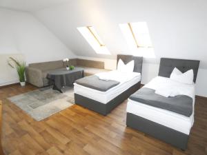 una sala de estar con dos camas y un sofá en SUNNYHOME Monteurwohnungen und Apartments in Schwandorf, en Schwandorf