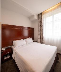 Un dormitorio con una cama grande y una ventana en The Quay Hotel West Coast en Singapur
