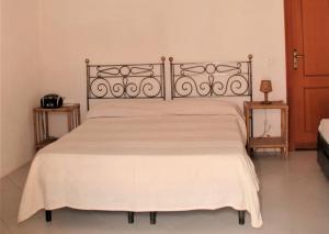 una camera da letto con un grande letto e un copriletto bianco di Case Mare - terrazzi panoramici e ampio giardino a Santa Marina Salina