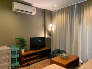 een woonkamer met een flatscreen-tv en een bank bij The Valley Khao Yai in Ban Huai Sok Noi
