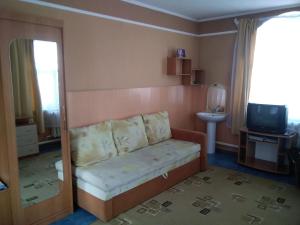 un soggiorno con divano e TV di Гостевой дом a Belokurikha