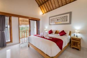 a bedroom with a large bed and a window at NG Sweet Home in Nusa Penida