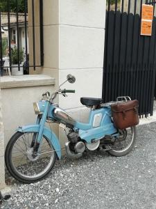 Una motocicleta azul estacionada al lado de un edificio en Thunder Roadhouse, en La Mothe-Saint-Héray