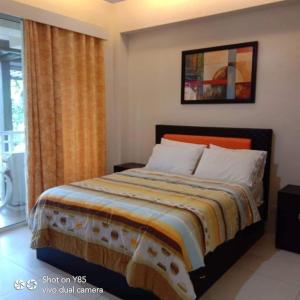 a bedroom with a large bed with an orange head board at Creys Condo 3 at Pico De Loro Cove in Nasugbu
