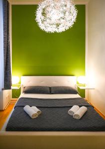 a bedroom with a green wall and a bed with two towels at Highlight Suite Universitaet Wien in Vienna