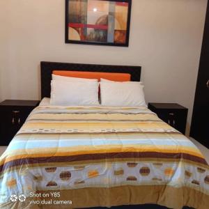 a bed with an orange headboard and white pillows at Creys Condo 3 at Pico De Loro Cove in Nasugbu