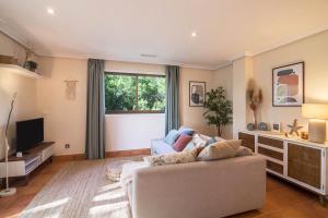 ein Wohnzimmer mit einem Sofa und einem TV in der Unterkunft Falésia Pine Spot in Albufeira