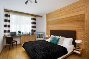 a bedroom with a large bed with a wooden wall at Naturpark Chalets Lambrecht by ALPS RESORTS in Sankt Lambrecht