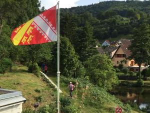 a flag on a hill next to a river at Appartements Maison Bellevue in Munster
