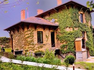 a large brick house with ivy growing on it at Lodges Lao in Bully