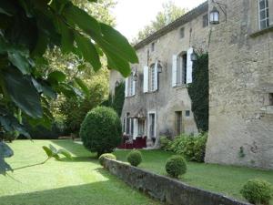 - un vieux bâtiment en pierre avec une cour devant dans l'établissement Chambres d'Hôtes Château Beaupré, à Saint-Laurent-des-Arbres