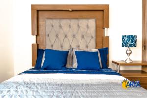a bedroom with a large bed with blue pillows at Disfruta Vallarta, lindo departamento, gran ubicación alberca, nuevo in Puerto Vallarta +56 photos