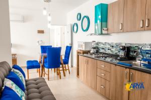 a kitchen with wooden cabinets and blue chairs at Disfruta Vallarta, lindo departamento, gran ubicación alberca, nuevo in Puerto Vallarta