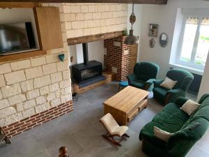 a living room with a couch and a fireplace at Aux doux logis in Gouy-Saint-André