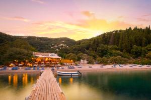 a dock with a boat in the water next to a beach at Villa Eva Agni with private pool by DadoVillas in Agní