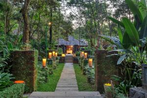 a path leading to a house in the jungle with lights at Club Mahindra Madikeri, Coorg in Madikeri