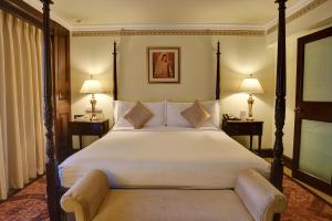 a hotel room with a large bed and two lamps at Pearl Continental Hotel, Lahore in Lahore