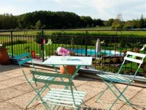 two chairs and a table in front of a pool at Le Clos Marie in Langeais