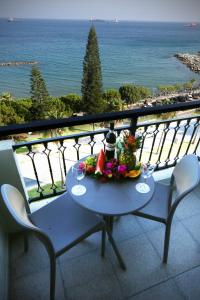 リマソールにあるピア ビーチ ホテル アパートメンツの海の景色を望むバルコニーに花のテーブル