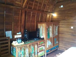 a room with a tv and a wooden wall at Bemo Villas & Pool in Karangasem