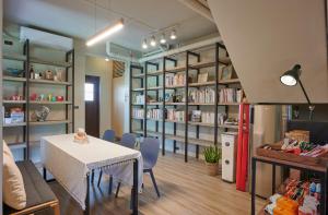 a room with a table and chairs and book shelves at Travel 345 in Luzhu