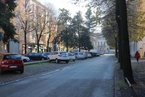 a street with cars parked on the side of the road at Fontana del Trianon Apartment in Parma
