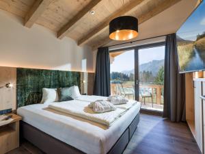 sypialnia z dużym łóżkiem i dużym oknem w obiekcie Chalets Weitblick Mariasteinerhof w mieście Mariastein