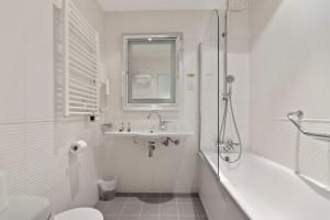 a white bathroom with a tub and a sink and a toilet at Napoleon in Ajaccio