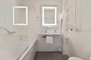 a white bathroom with a sink and a tub and a toilet at Napoleon in Ajaccio