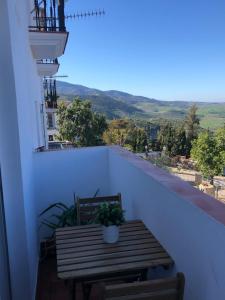 a wooden table on a balcony with a view at Casas PARAJE NATURAL in Zahara de la Sierra