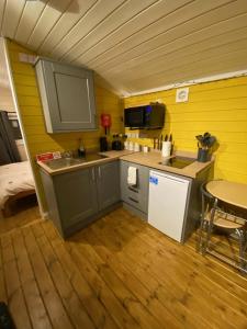 uma pequena cozinha com um lavatório e uma mesa em Cherry Tree Glamping em Stroud