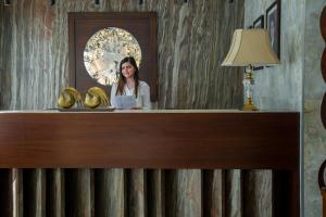 a woman standing behind a counter with bananas on it at Seas Hotel Amman in Amman