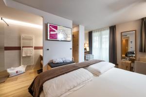 a bedroom with a large bed with a sign on the wall at Family Hotel Serena in Andalo